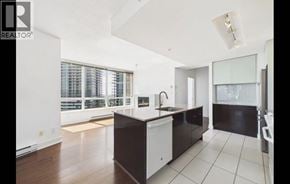 Burnaby apartment for rent - A modern kitchen with white cabinets and a black island.