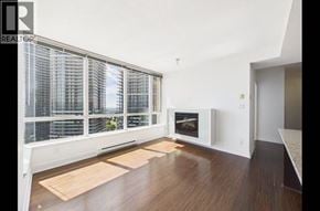 Burnaby apartment for rent - A living room with a fireplace and a large window with blinds.