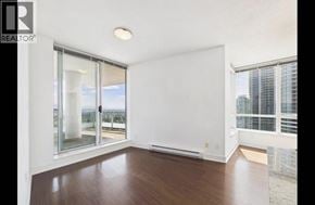 Burnaby apartment for rent - A spacious room with a view of the city through the windows.