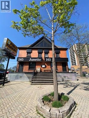 Windsor apartment for rent - A tree in front of a building with the number 165 Janette on it.