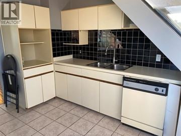 Windsor apartment for rent - A kitchen with white cabinets and a black dishwasher.