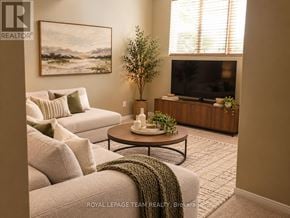 Ottawa townhouse for rent - A living room with a couch, a coffee table, a television, and a plant.