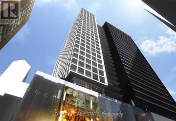 Toronto (Bay Street Corridor) condo for rent - A tall building with a glass facade and a sign that reads "LOYALTY REAL ESTATE Brokerage".