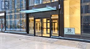 Toronto (Bay Street Corridor) condo for rent - The entrance to a building with a glass facade and a sign that reads "20 EDWARD ST."