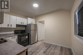 London East (East K) duplex for rent - A kitchen with white cabinets and a black stove top oven.