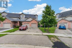 Kitchener townhouse for rent - A red car is parked in front of a house with a sign that says REALTOR.