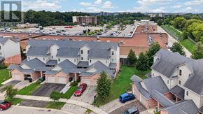 Kitchener townhouse for rent - A brokerage company is advertising a residential area with houses and a parking lot.