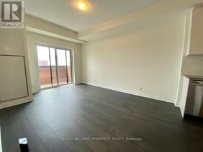 Oakville (Go Glenorchy) condo for rent - A spacious room with a sliding glass door leading to a balcony.