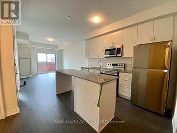 Oakville (Go Glenorchy) condo for rent - A kitchen with white cabinets and a stainless steel refrigerator.