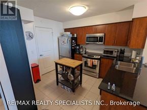 Toronto (Islington-City Centre West) condo for rent - A kitchen with a refrigerator, microwave, oven, and sink.