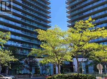 Toronto (Willowdale West) condo for rent - Two trees in front of a building with the words Master's Trust Realty on it.