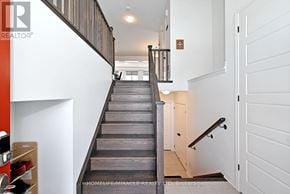 Innisfil apartment for rent - A staircase with a wooden handrail and a white wall on the side.