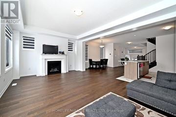 Innisfil apartment for rent - A living room with a grey couch and a fireplace.