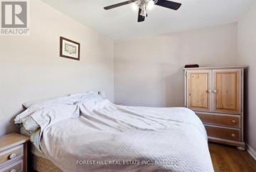 Toronto (Lawrence Park South) multi-family for rent - A bedroom with a bed, a ceiling fan, and a wooden cabinet.