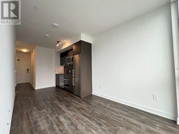 Toronto (Waterfront Communities) condo for rent - A spacious room with a kitchenette and wooden flooring.