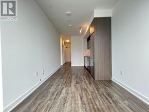 Toronto (Waterfront Communities) condo for rent - A long hallway with wood flooring and white walls.
