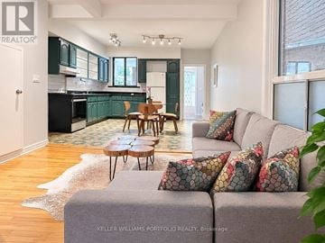 Toronto (Dovercourt-Wallace Emerson-Junction) apartment for rent - A living room with a grey couch and a wooden table.