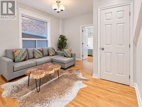 Toronto (Dovercourt-Wallace Emerson-Junction) apartment for rent - A living room with a grey couch and a rug.