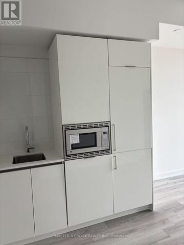 Toronto (Kensington-Chinatown) condo for rent - A white kitchen cabinet with a microwave built in.