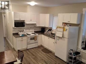 Burnaby apartment for rent - A kitchen with white cabinets and appliances.