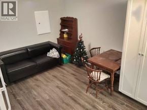 Burnaby apartment for rent - A living room with a black couch, a wooden table, and a Christmas tree.