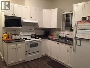 Burnaby apartment for rent - A kitchen with white cabinets and appliances.