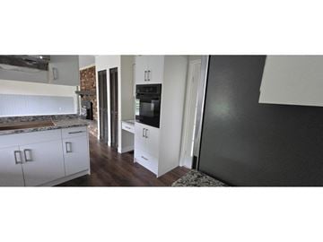 Surrey apartment for rent - A kitchen with white cabinets and a black refrigerator.