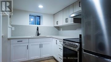 Toronto (Lawrence Park South) multi-family for rent - A kitchen with white cabinets and a stainless steel refrigerator.
