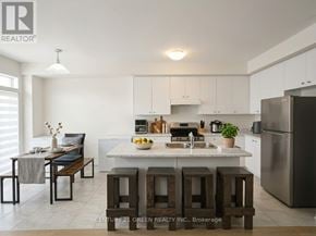 Thorold (Rolling Meadows) apartment for rent - A kitchen with white cabinets and a stainless steel refrigerator.