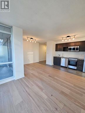 Toronto (Waterfront Communities) condo for rent - A modern kitchen with wooden floors and stainless steel appliances.