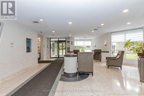 Brampton (Queen Street Corridor) condo for rent - A spacious living room with a grey carpet and a white pillar.