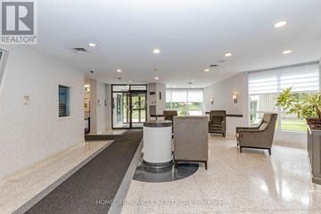 Brampton (Queen Street Corridor) condo for rent - A spacious living room with a grey carpet and a white pillar.