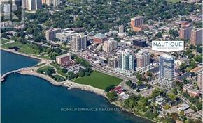 Burlington (Brant) condo for rent - An aerial view of a city with a large body of water and a sign that reads "Nautique.".
