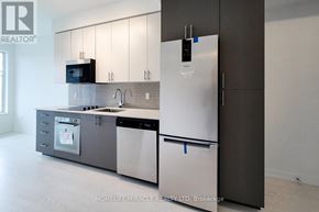 Hamilton (Kirkendall) condo for rent - A modern kitchen with a refrigerator, microwave, and dishwasher.
