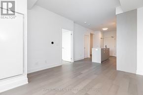 Toronto (Yonge-Eglinton) condo for rent - A spacious, empty room with a refrigerator in the corner.