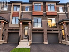 Brantford townhouse for rent - A large, modern apartment building with multiple garages.