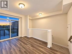 Brantford townhouse for rent - A well-lit, empty room with a sliding glass door leading to a balcony.