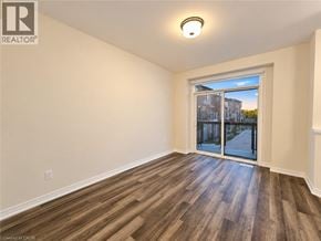 Brantford townhouse for rent - A room with wooden flooring and a sliding glass door leading to a balcony.