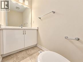Brantford townhouse for rent - A white bathroom with a tub, sink, and mirror.