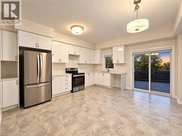 Brantford townhouse for rent - A spacious kitchen with white cabinets and a stainless steel refrigerator.
