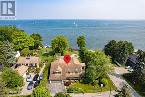 Oakville (Sw Southwest) apartment for rent - A house with a red pin on it is surrounded by greenery and overlooks a body of water with sailboats.