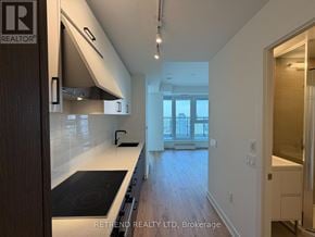 Toronto (Banbury-Don Mills) condo for rent - A modern kitchen with a stove top oven and a window.
