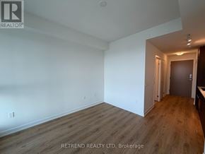 Toronto (Banbury-Don Mills) condo for rent - A room with wooden flooring and white walls, with a door on the right side.
