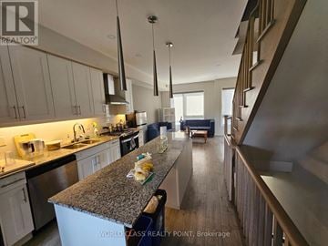 Oshawa (Samac) townhouse for rent - A kitchen with a granite countertop and stainless steel appliances.
