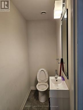 Oshawa (Samac) townhouse for rent - A white toilet sits next to a sink in a small bathroom.