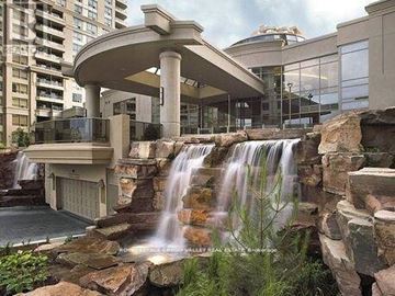 Mississauga (City Centre) condo for rent - A waterfall flows from a balcony into a pool below.