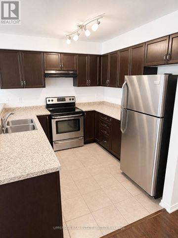 Innisfil (Alcona) townhouse for rent - A kitchen with a refrigerator, oven, and sink.