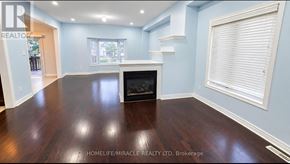 Brampton (Sandringham-Wellington) apartment for rent - A spacious living room with a fireplace and hardwood floors.