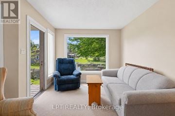 Georgina (Keswick North) duplex for rent - A living room with a blue chair and a grey couch.