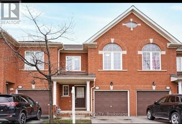 Mississauga (Meadowvale Village) townhouse for rent - A red brick house with a black car parked in front.